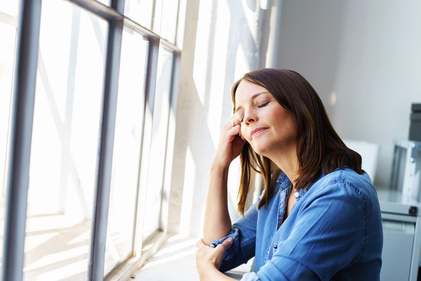 stressed woman by window trying to relax